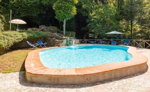 una gran piscina con sillas y sombrilla en Molin Barletta - Nice Holiday House With Private Pool Marliana, Toscana en Marliana