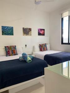 two beds in a room with paintings on the wall at Family Apartments Near Beach Polo88 in Playa del Carmen