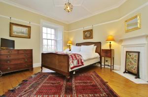1 dormitorio con 1 cama, vestidor y TV en Elegant 3-Bedroom Ramsay Garden Apartment in Edinburgh City Centre, en Edimburgo