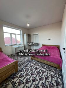 1 dormitorio con 2 camas y alfombra en Emir Guest House in Karakol en Karakol