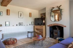 a living room with a blue couch and a fireplace at Lovely 2 BD with stunning views over Stroud valley 