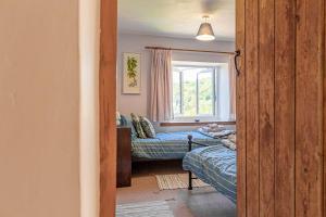 1 dormitorio con cama y ventana en Lovely 2 BD with stunning views over Stroud valley 