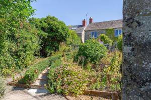 un jardín con muchas plantas y una casa en Lovely 2 BD with stunning views over Stroud valley 