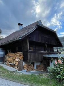 een houten huis met een stapel brandhout bij Haus Lahner in Bad Bleiberg