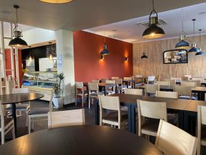a restaurant with tables and white chairs and tables and tablesktop at St James Apartment in Luz