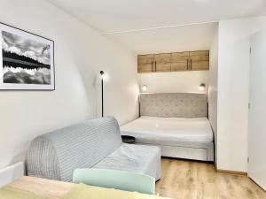 ein kleines Zimmer mit einem Bett und einem Sofa in der Unterkunft Port Jáchymov in Jáchymov