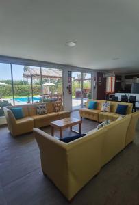 a living room with yellow couches and a table at Bungalow Sol del Sur in Paracas