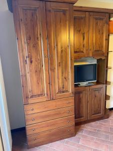 Vittoria Sweet Home في Ateleta: خزانة خشبية كبيرة مع تلفزيون في المطبخ