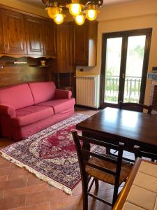Vittoria Sweet Home في Ateleta: غرفة معيشة مع أريكة وردية وطاولة