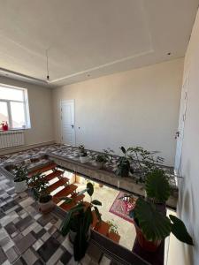 a large room with potted plants in a room with a floor at Emir Guest House in Karakol in Karakol