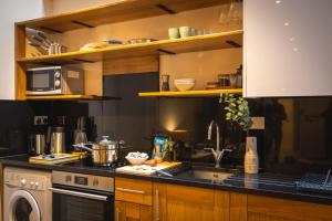 cocina con fregadero y fogones horno superior en The Courtfield - Serviced Apartments en Londres