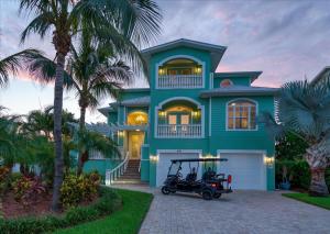 a blue house with a golf cart in front of it at Waterfront Luxury w/ Heated Salt Pool & Golf Cart in Clearwater Beach