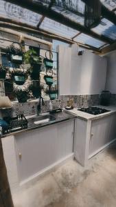 a kitchen with white cabinets and a sink at Buddy's Hostel Itacaré in Itacaré