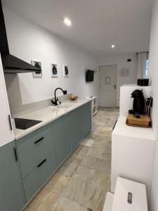 a kitchen with a sink and a white refrigerator at Apartamento a 8km Sevilla centro in Valencina de la Concepción
