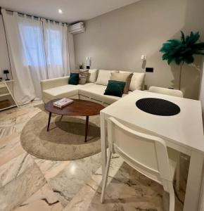 ein Wohnzimmer mit einem weißen Sofa und einem Tisch in der Unterkunft Apartamento a 8km Sevilla centro in Valencina de la Concepción