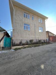 un edificio con una valla delante en Emir Guest House in Karakol, en Karakol
