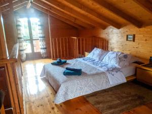 Olive Grove Chalet في نافباكتوس: غرفة نوم عليها سرير وفوط زرقاء