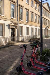 two scooters are parked in front of a building at Georgian House Garden Apartment in Bath