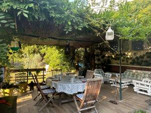 un patio con mesa, sillas y árboles en la villa provençale, en La Motte-Chalançon
