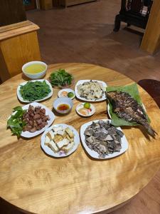 Homestay Hoà Thảo في Mù Cang Chải: طاولة عليها أطباق من الطعام