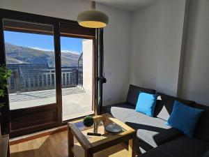 IMEDA Apartamento LOS ALPES I في سييرا نيفادا: غرفة معيشة مع أريكة ونافذة كبيرة