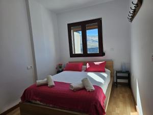 IMEDA Apartamento LOS ALPES I في سييرا نيفادا: غرفة نوم بسرير ومخدات حمراء ونافذة