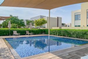 uma piscina com duas cadeiras e um guarda-sol em Frank Porter - Urbana 3 em Dubai