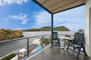 2 sillas en un balcón con vistas al agua en Hotel Do Caracol, en Angra do Heroísmo