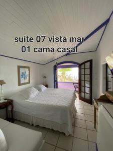 1 dormitorio con 1 cama blanca en una habitación en Casa da Ruth Pousada, en Búzios
