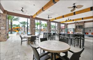 a patio with tables and chairs and a kitchen at Orlando Relax in Davenport
