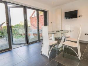 a dining room with a table and chairs and windows at Beautiful Holiday Home Village Sleeps up to 6 in West Hallam
