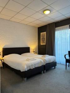 een slaapkamer met een groot bed in een kamer bij Hotel Schimmel in Woudenberg