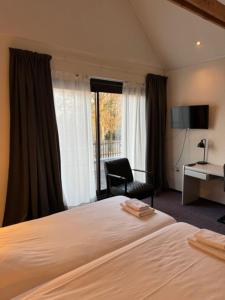 a hotel room with a bed and a chair and a window at Hotel Schimmel in Woudenberg