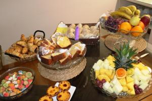 a table topped with baskets of different types of food at Hotel Larverde in Sertã