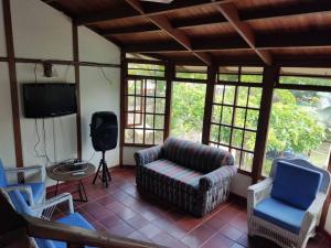 a living room with a couch and chairs and a television at Las Palmeras casa en Melgar in Melgar