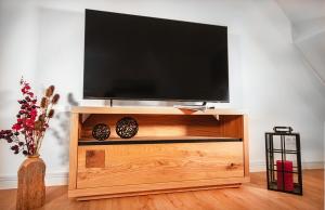 un centro de entretenimiento de madera con TV de pantalla plana en Bocksberg-Lodge, en Goslar