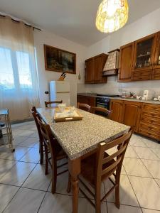 een keuken met een tafel met stoelen en een koelkast bij Colle Perazzoni in Fiano Romano