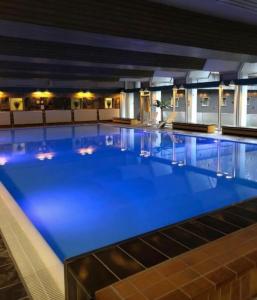 een groot zwembad met blauw water in een gebouw bij Ferienwohnung Carpe Diem in Bad Harzburg
