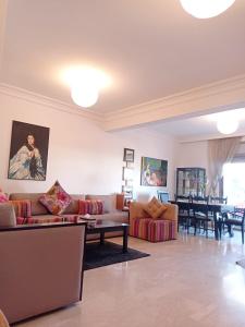a living room with couches and a dining room at Bel appartement à skhirat plage et à 20 mn de Rabat in Skhirat