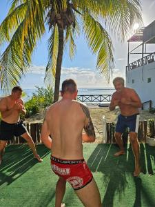 a group of men standing under a palm tree at Villa on The Beach Seaside Sunrise Haven 7 bedroom in Cancún