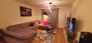 ein Wohnzimmer mit einem Sofa und einem Flachbild-TV in der Unterkunft Luxurious and spacious 1 bd flat in Basildon