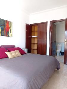 a bedroom with a large bed and a bathroom at Bel appartement à skhirat plage et à 20 mn de Rabat in Skhirat