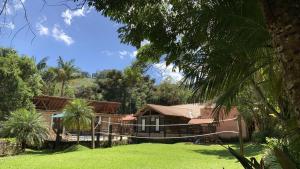 uma casa com um relvado verde em frente em Serra do Ibitipoca Hotel de Lazer em Conceição do Ibitipoca