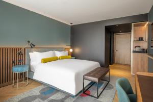 sypialnia z dużym białym łóżkiem i krzesłem w obiekcie Renaissance Porto Lapa Hotel w Porto