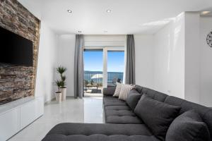 ein Wohnzimmer mit Sofa und Fernseher in der Unterkunft Villa Nonna Tonina in Podstrana