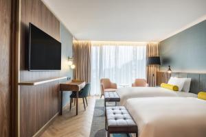ポルトにあるRenaissance Porto Lapa Hotelのベッド2台とデスクが備わるホテルルームです。