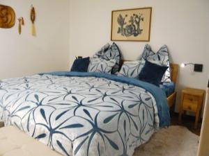 Schlafzimmer mit einem Bett mit einer blauen und weißen Bettdecke in der Unterkunft Sport Alpin Wohnung 110 in Oberstdorf