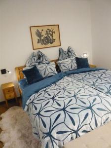 Schlafzimmer mit einem großen Bett mit blauer und weißer Bettwäsche in der Unterkunft Sport Alpin Wohnung 110 in Oberstdorf