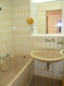 ein Badezimmer mit einem Waschbecken und einer Badewanne in der Unterkunft Sport Alpin Wohnung 110 in Oberstdorf