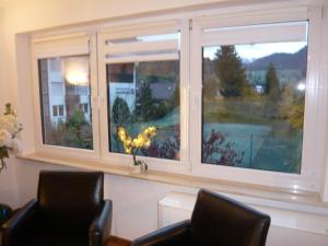 ein Fenster in einem Zimmer mit zwei Stühlen davor in der Unterkunft Sport Alpin Wohnung 110 in Oberstdorf